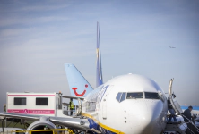 Close-up of a Ryanair Boeing 747 with passengers using stairs on the right and an ambulift at the central exit on the left.