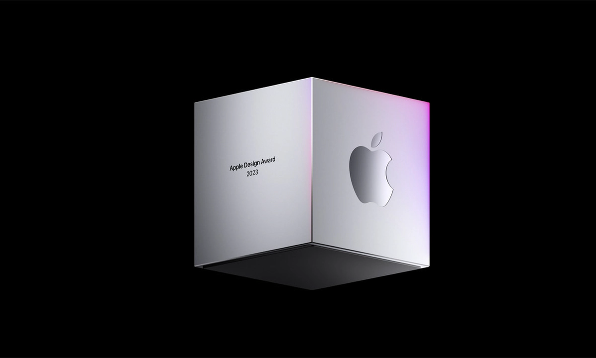 A silver three-dimensional cube floating against a black background, with the text Apple Design Awards 2023 on one face of the shape, and the Apple logo on another face of the shape.