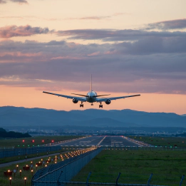 Photo of a plane above a runway at sunset. Photo of a plane above a runway at sunset.