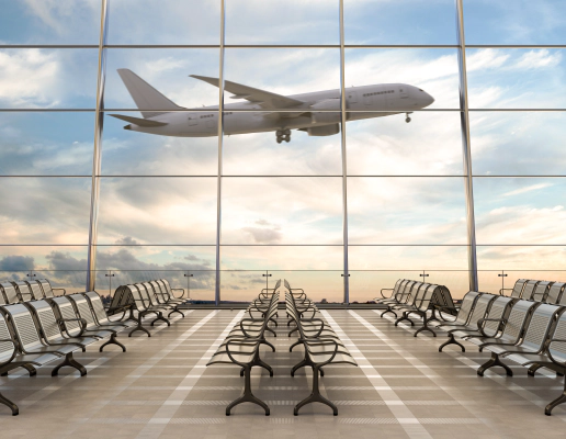 صالة مطار فارغة ذات نوافذ زجاجية ممتدة من الأرض حتى السقف وتطل على مدرج المطار، مع وجود طائرة ركاب تجارية في منتصف إقلاعها في الخلفية.