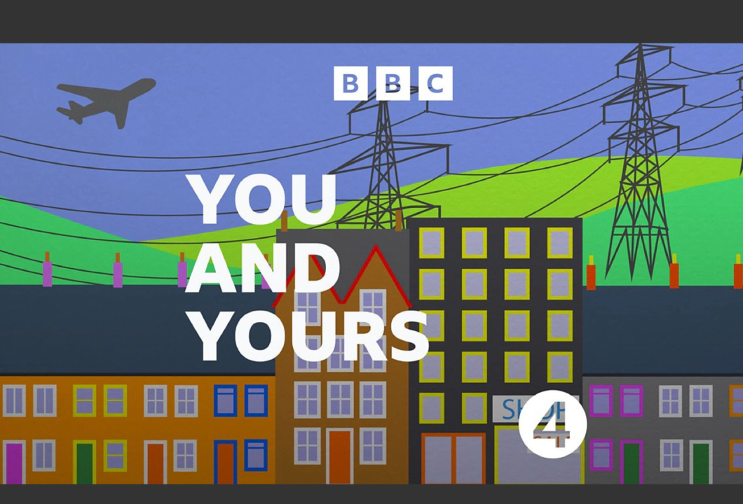4 رسم كاريكاتوري لصف من المنازل المتلاصقة أمام التل الأخضر، مع برجين للكهرباء موضوعين فوقه. يتراكب على هذا شعار بي بي سي، والنص "أنتم ولكم"، وشعار راديو بي بي سي.