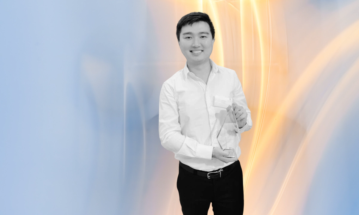 Jay Shen, an asian man with short black hair, and CEO of Transreport, smiling and holding an award.