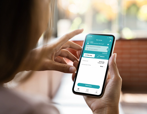 The hands of a woman holding a mobile phone, using the Passenger Assistance app.