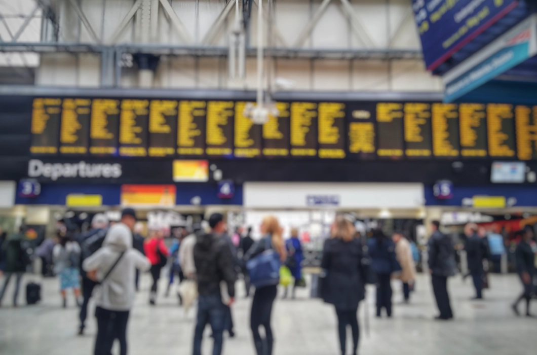 Blurred image of crowded passengers in Waterloo looking at the timetable.