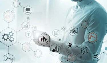 The torso of a man wearing a button-up shirt holding a mobile phone, with an interconnected matrix of various process icons overlayed on top.