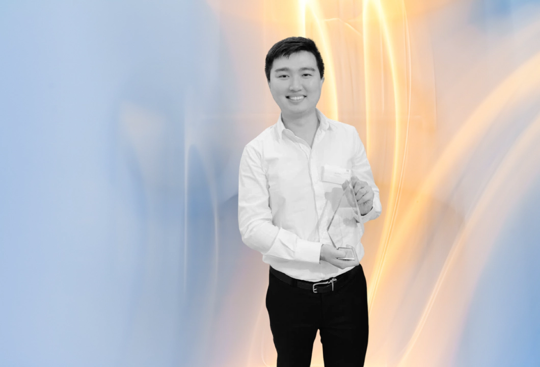 賞状を手にして微笑む、黒髪のショートヘアのアジア人男性で、トランスレポートのCEO、Jay Shen。