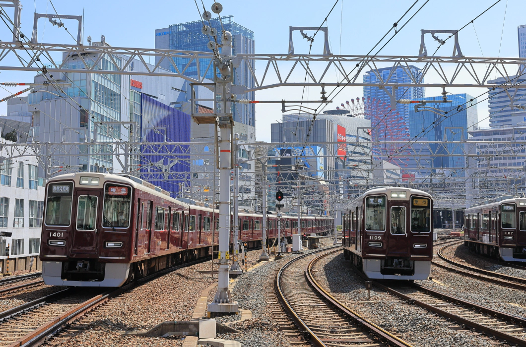 日本の駅で線路を進む2台の赤い電車
