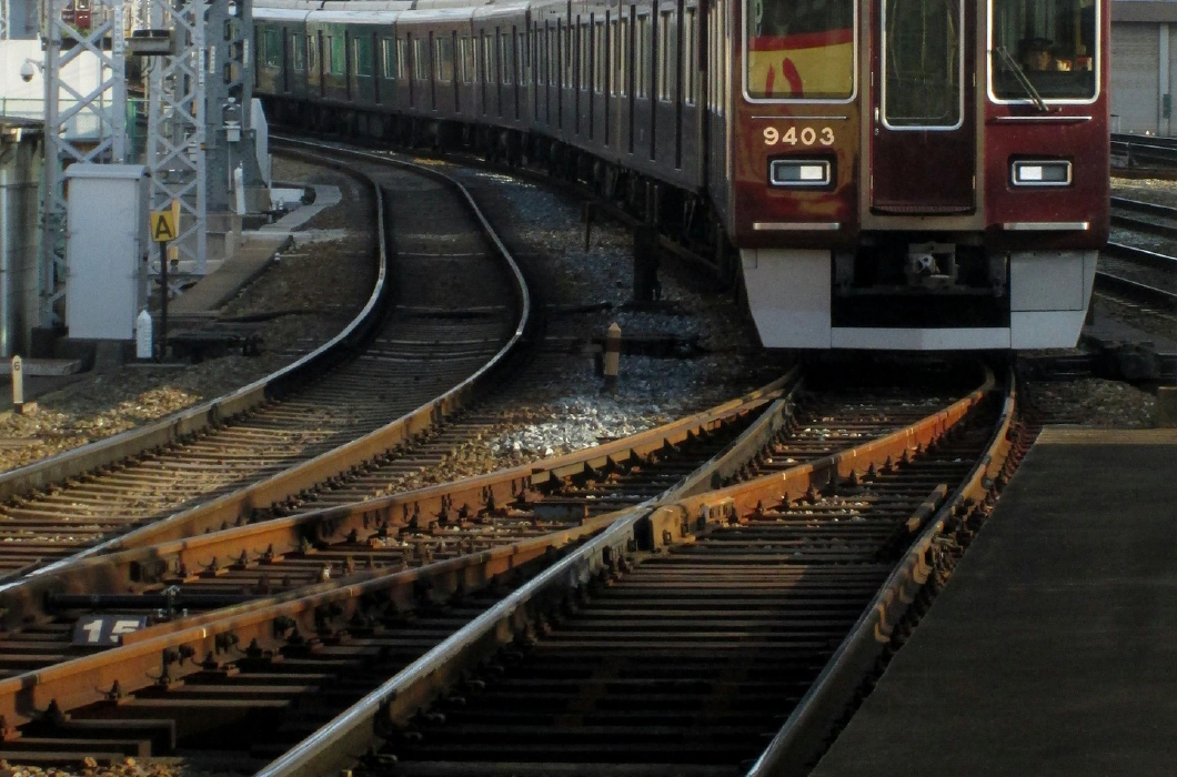 大阪駅線路上の、えんじ色の阪急電車の写真
