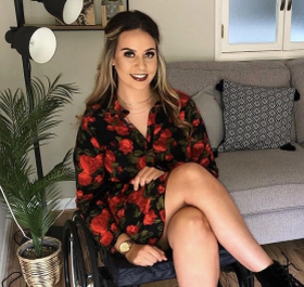 Jennie Berry, a white female with blonde hair facing the camera smiling sitting in a wheelchair