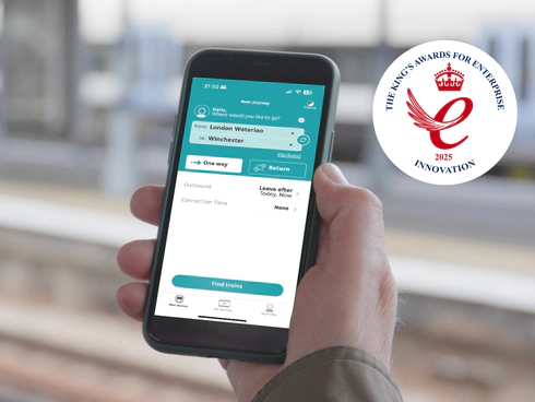 On the left, a teal background with Transreport logo in white and the King’s Awards for Enterprise 2025 Innovation emblem are displayed. On the right, a person uses the Passenger Assistance app on a smartphone to plan a train journey from London Waterloo to Winchester.