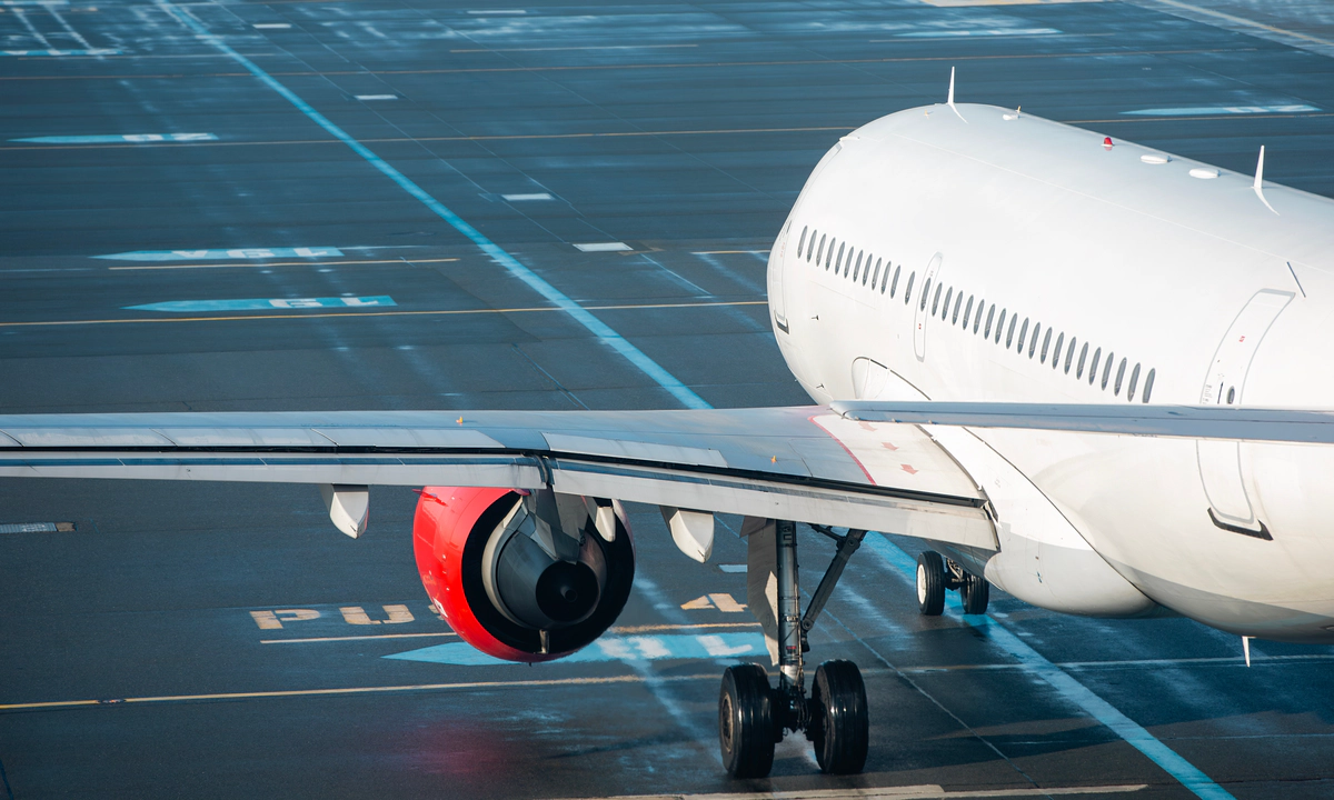 Photo of a white plane on a runway.