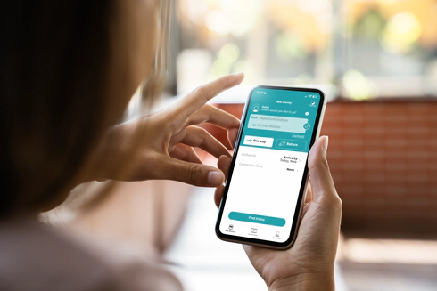 The hands of a woman holding a mobile phone, using the Passenger Assistance app.
