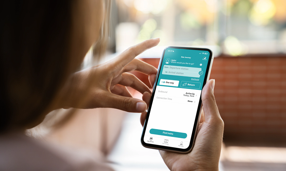 The hands of a woman holding a mobile phone, using the Passenger Assistance app. The hands of a woman holding a mobile phone, using the Passenger Assistance app.